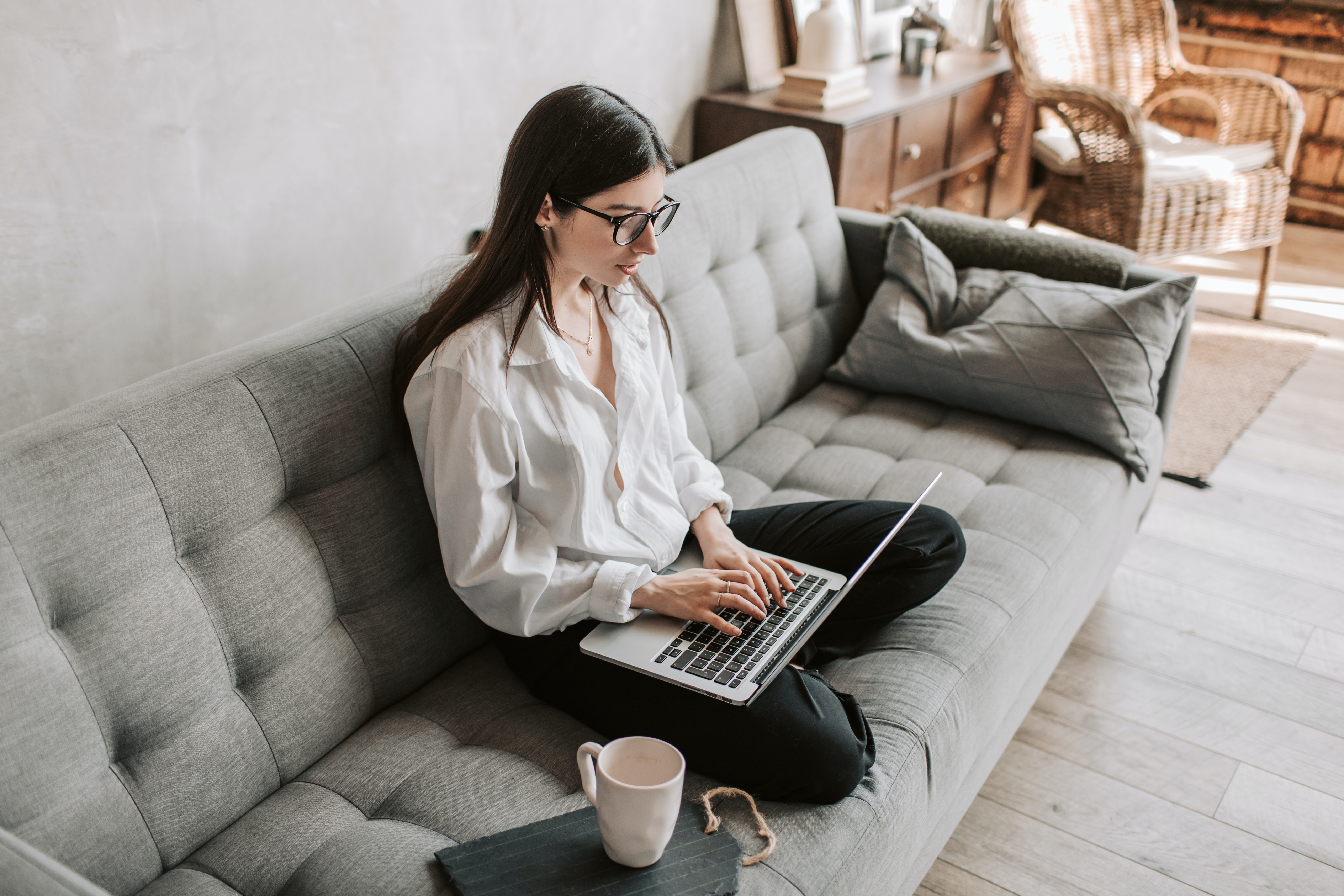 Woman working on her computer while sitting n the sofa